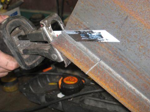 1978 Ford Bronco - A close-up view shows a reciprocating saw in action, cutting through a piece of metal.