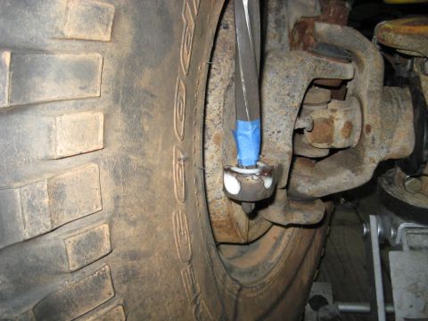 1978 Ford Bronco - This image shows a close-up view of a vehicle's suspension system, focusing on a tie rod end and part of a large tire.