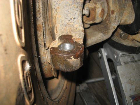 1978 Ford Bronco - Rusted vehicle suspension part shown with a jack, likely undergoing maintenance or repair.