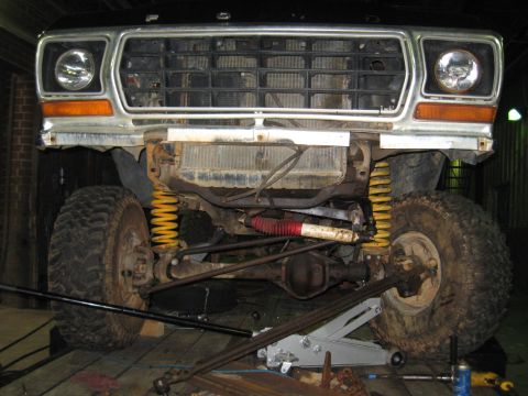 1978 Ford Bronco - Front view of a 1978 Ford Bronco showing its grille, headlights, and suspension system, which is supported by a jack.