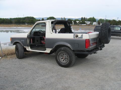 1991 Ford Bronco - This modified Ford Bronco has its doors removed and a roll cage visible inside.