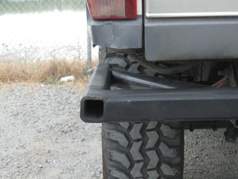 1991 Ford Bronco - Close-up of a vehicle's rear bumper and tire, showing a receiver hitch.