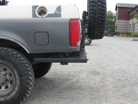 1991 Ford Bronco - The rear quarter panel of a 1991 Ford Bronco features a swing-away spare tire carrier and external fuel filler.