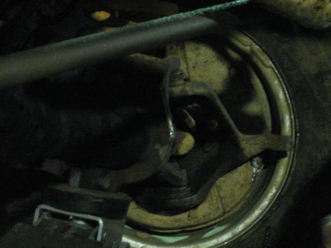 1978 Ford Bronco - A detailed view of the front suspension and wheel assembly, highlighting the brake components and tire.