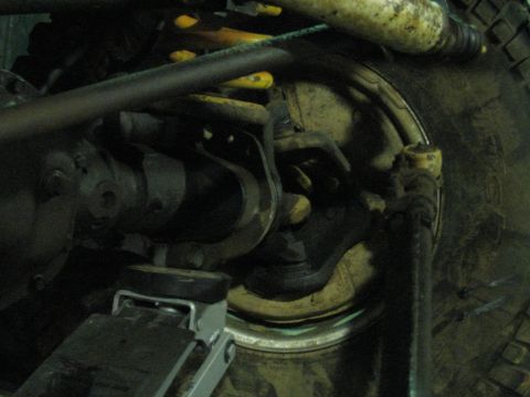 1978 Ford Bronco - A vehicle's suspension system and tire are visible, with a jack supporting the frame.