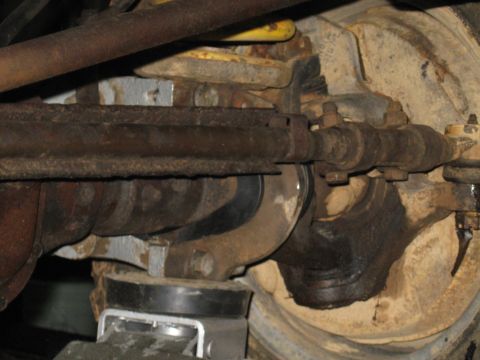 1978 Ford Bronco - Detail of vehicle's front suspension and steering mechanism, showing wear and rust on components.