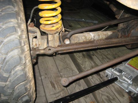 1978 Ford Bronco - Detail view of a vehicle's suspension system, showing steering components and a coil spring.