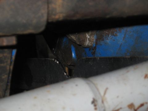1978 Ford Bronco - A close-up view shows the underside of a vehicle, focusing on frame and suspension components with visible blue paint.