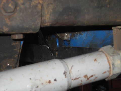 1978 Ford Bronco - Close-up view of a vehicle's undercarriage, showing mechanical parts and a blue painted component.