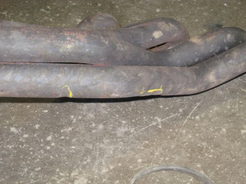 1978 Ford Bronco - Close-up of a corroded exhaust manifold, showing signs of wear and repair marks.