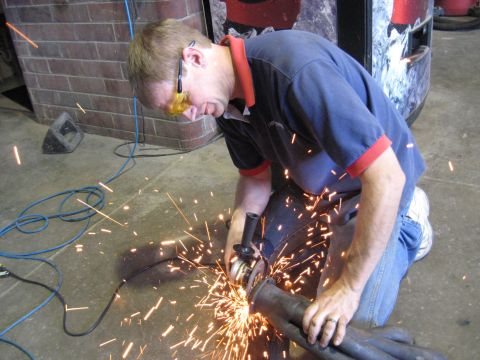 1978 Ford Bronco - Grinding an exhaust pipe with an angle grinder.