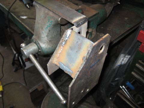 1978 Ford Bronco - A metal bracket, recently welded, is secured in a vise on a workbench.