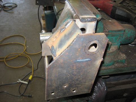 1978 Ford Bronco - Metal bracket being worked on in a vise, with tools and electrical cords visible.