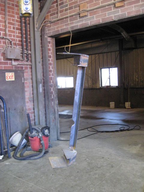 1978 Ford Bronco - A metal fabrication part stands in a workshop, with a shop vac and an exit door visible.