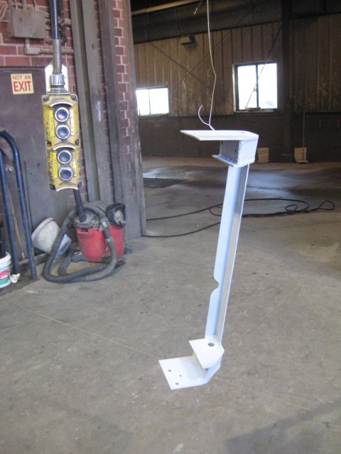 1978 Ford Bronco - A metal bracket, likely for industrial use, sits on a concrete floor in a workshop.