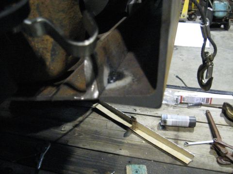 1978 Ford Bronco - A metal bracket is shown, possibly undergoing repair or fabrication, with tools and equipment in the background.