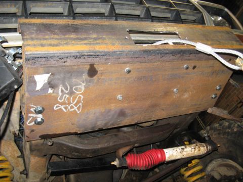 1978 Ford Bronco - A close-up view of a custom skid plate attached to the front of a 1978 Ford Bronco, showing its grille and suspension.