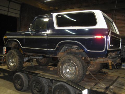1978 Ford Bronco - This 1978 Ford Bronco, seen on a trailer, features a dark blue body with a white hardtop and BFGoodrich tires.