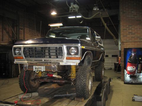 1978 Ford Bronco - A dark blue Ford Bronco is shown on a trailer in a garage, a prominent grille and a winch on the front bumper.