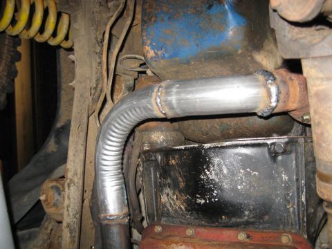 1978 Ford Bronco - Custom exhaust pipe repair showing a flexible section and fresh welds on a vehicle's underside.