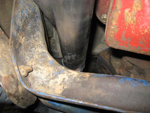 1978 Ford Bronco - Close-up view of exhaust pipe and suspension parts, showing rust and wear.