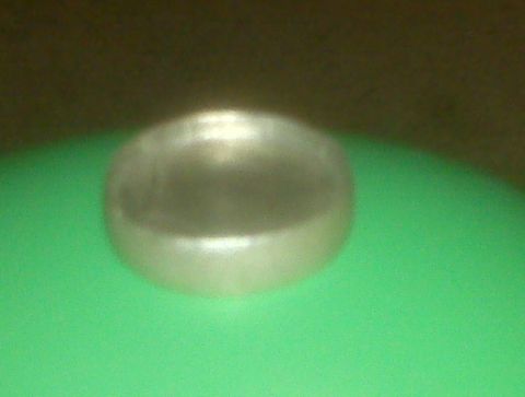1995 Ford Bronco - A single silver hubcap is shown against a green background.