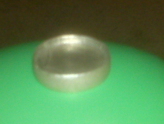 Silver hubcap on a green surface