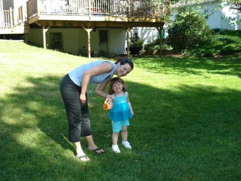 2000 Ford Crown Victoria - A woman and a small child pose for a photo in a sunny backyard with a deck and house in the background.