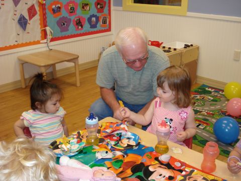 2000 Ford Crown Victoria - A man interacts with two young children at a table decorated with cartoon characters.