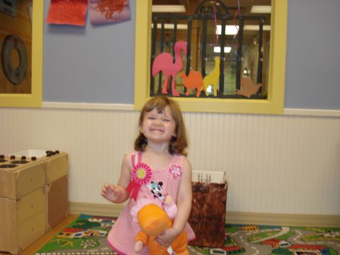 2000 Ford Crown Victoria - A young girl smiles while holding a stuffed animal in a room decorated with colorful animal cutouts.