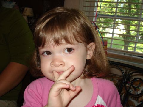 2000 Ford Crown Victoria - A young girl makes a shushing gesture while looking at the camera.