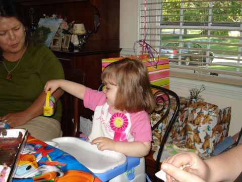 2000 Ford Crown Victoria - A young child celebrates a birthday, surrounded by gifts and family.