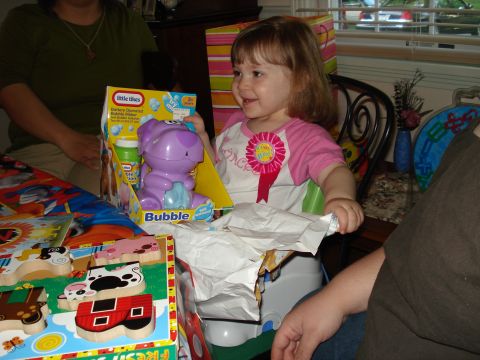 2000 Ford Crown Victoria - A young girl smiles as she opens a Little Tikes bubble maker toy, wearing a 'It's My Birthday' ribbon.