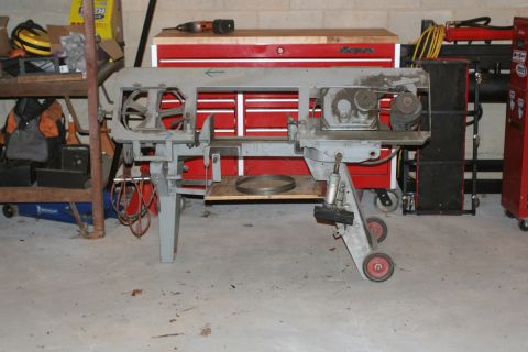 1990 Ford Bronco - Metal cutting bandsaw with red wheels and tool chests in the background.
