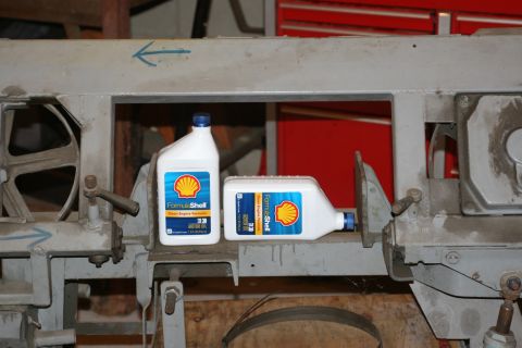 1990 Ford Bronco - Two bottles of Shell Formula Shell motor oil are placed on a metal frame, with one bottle lying on its side.