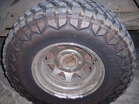 1991 Ford Bronco - A close-up view of a Hankook tire mounted on a silver wheel, showing off-road tread patterns.