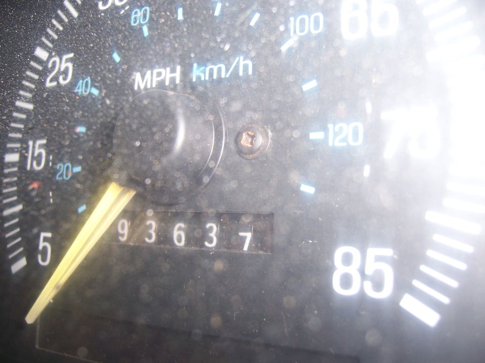 Dusty dashboard gauge cluster with odometer reading 93637