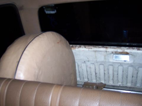 1991 Ford Bronco - Interior shot showing a spare tire cover and the rear bench seat of a vehicle.