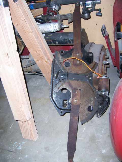 1991 Ford Bronco - A close-up view of a rusty window regulator mechanism, likely from a vehicle part.