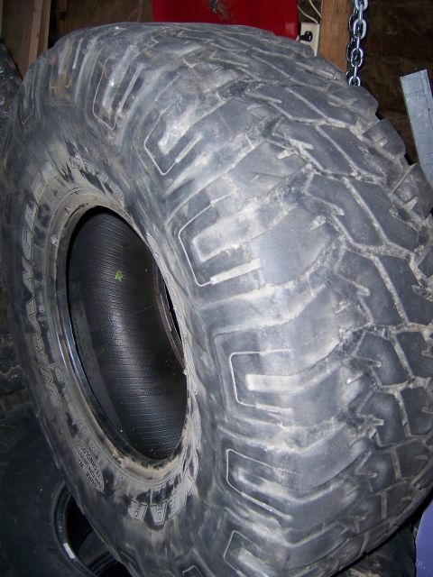 1991 Ford Bronco - A close-up view of a single tire, showing its tread design and sidewall markings.