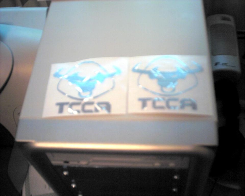 Two blue TCCA decals on a light-colored surface