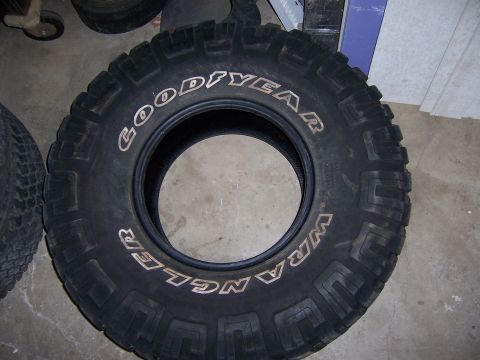 1991 Ford Bronco - A single Goodyear Wrangler tire is shown in detail, resting on a concrete floor.