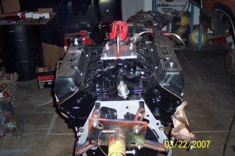 1979 Ford Bronco - A black V8 engine with a red distributor cap and chrome valve covers is shown in a garage setting. The engine appears to be a performance b…