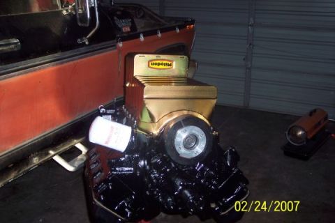 1979 Ford Bronco - A Miledon oil pan and engine block are shown, with a portion of a red vehicle visible in the background.