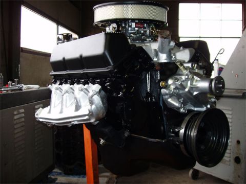 1979 Ford Bronco - A V8 engine with a chrome air cleaner and intake manifold is displayed on an orange stand.