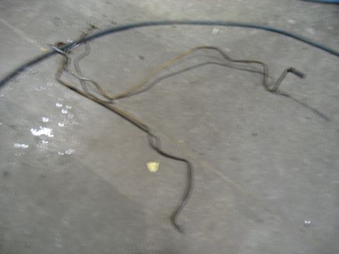 1978 Ford Bronco - Metal brake lines are shown on a concrete surface, possibly removed from a vehicle.