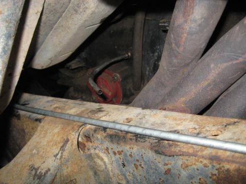 1978 Ford Bronco - Close-up view of a red fuel filter and exhaust manifold, likely from an older vehicle.