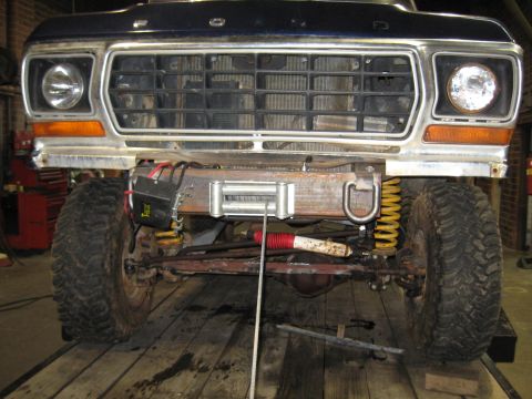 1978 Ford Bronco - The front of a Ford F-Series truck is shown, a winch and heavy-duty suspension components.