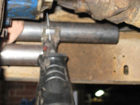 1978 Ford Bronco - A mechanic is working on an exhaust pipe, possibly for a vehicle.