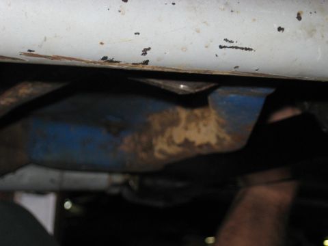 1978 Ford Bronco - Close-up view of the undercarriage of a vehicle, showing white painted metal and blue components.